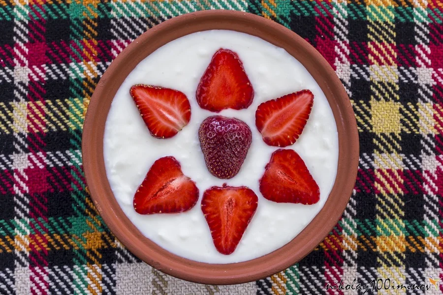 Strawberries sliced and beautifully arranged in a bowl of yogurt.