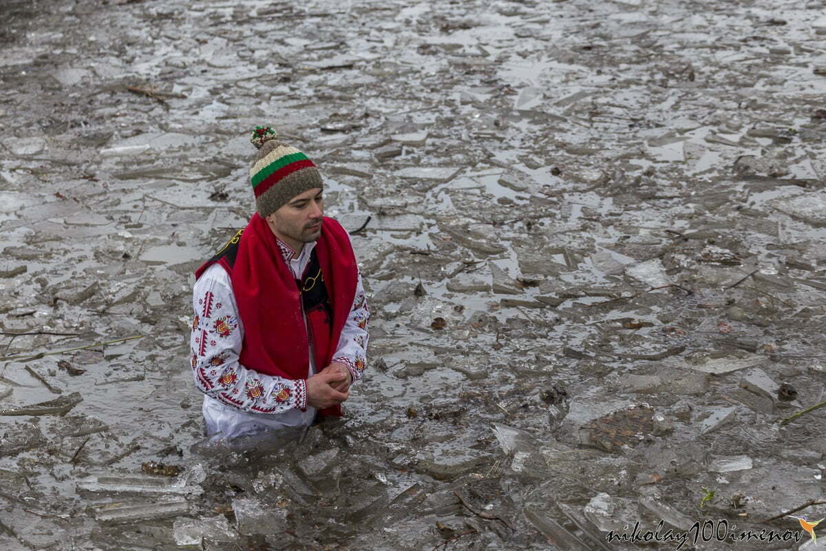 KALOFER, BULGARIA - JANUARY 06, 2019 - Traditional Bulgarian horo dance in the cold icy waters of Tundzha river in Kalofer city Bulgaria.