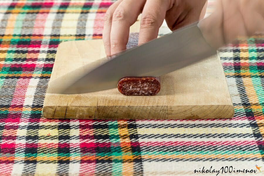 Cutting traditional Bulgarian flat sausage called lukanka