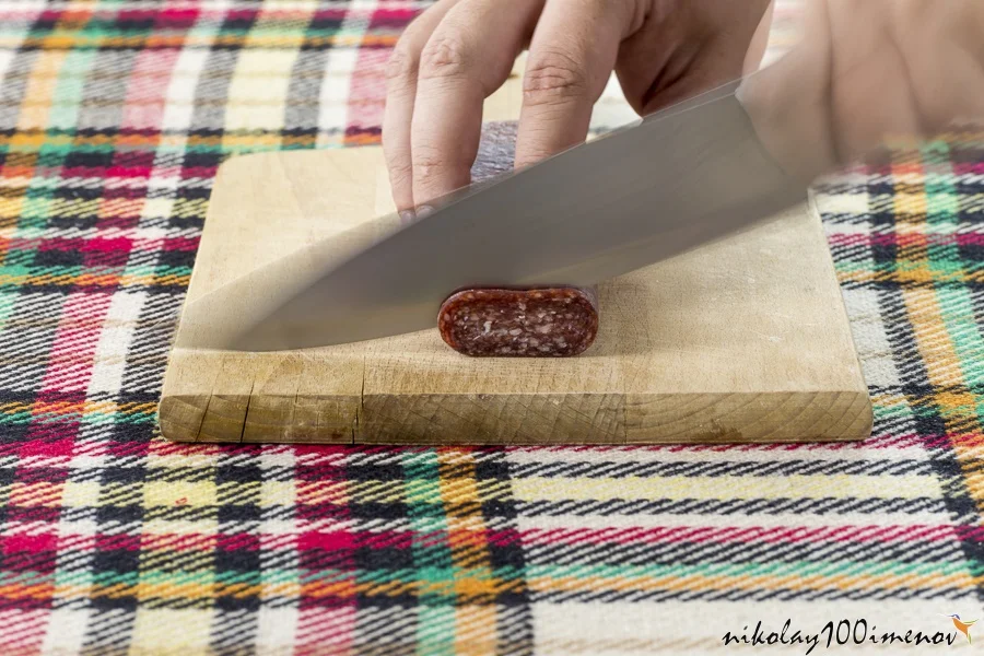 Cutting traditional Bulgarian flat sausage called lukanka