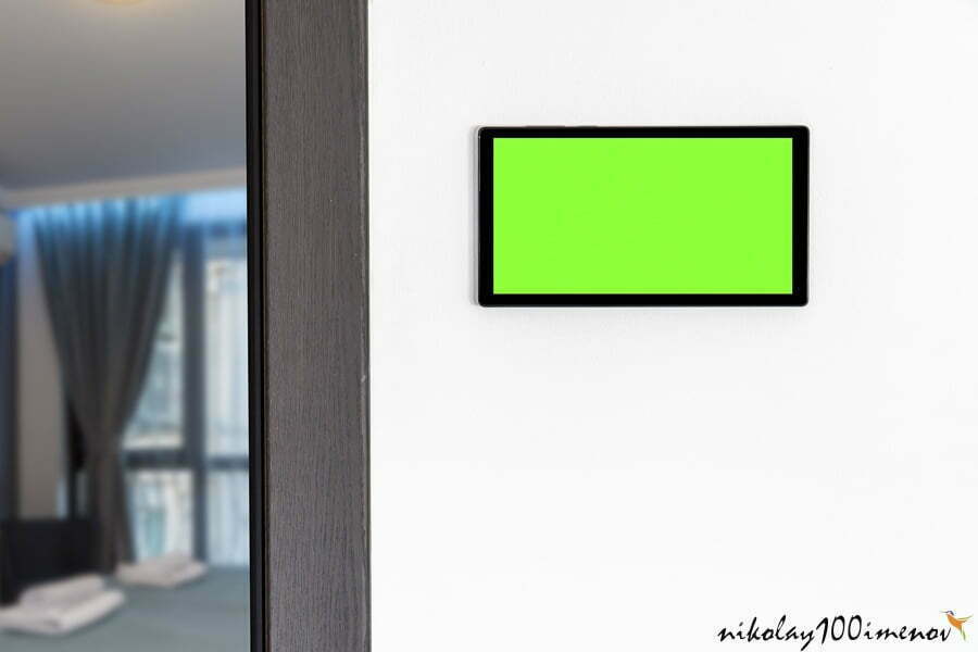 Home automation concept. Device with blank screen hanging on a wall.